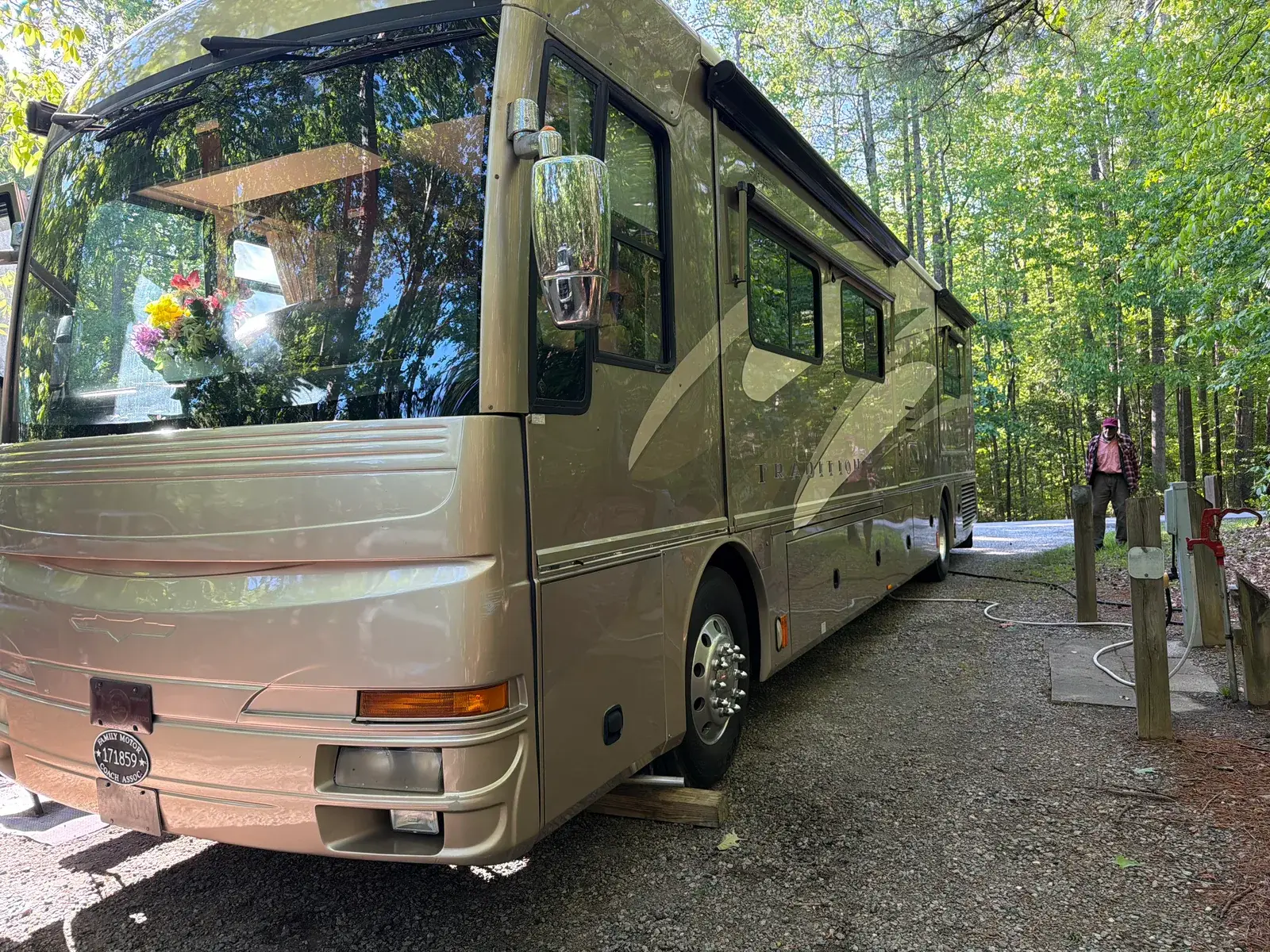A Class A motor home levelled on blocks at a wooded campsite for an on-site repair